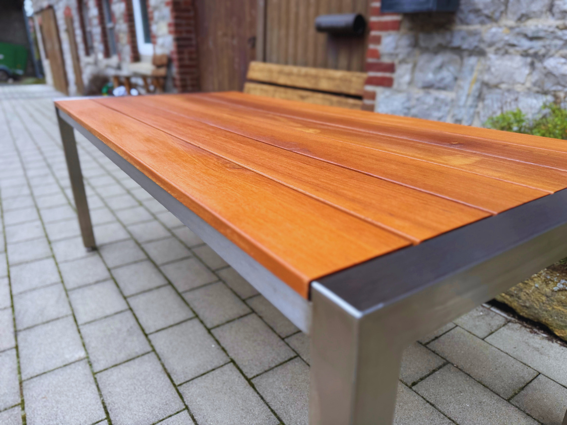 Detailansicht von Holzplatte und Edelstahlrahmen